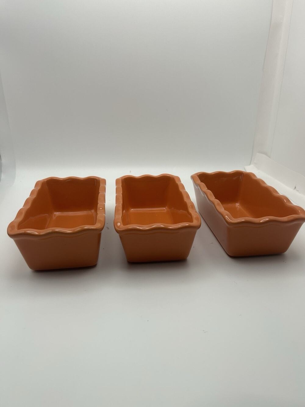 3 Stoneware Loaf Pans With Scalloped Edges.